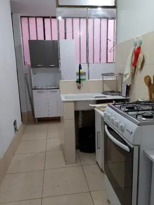 a small kitchen with a stove and a sink at MUNAYCHA`S WASI in Cusco