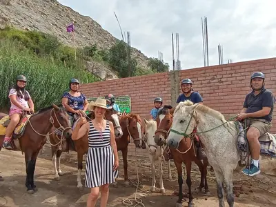 a group of people riding horses with a woman at Hotel Quilla Wasi in Lunahuaná