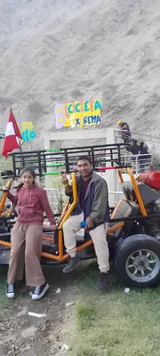 a man and a woman sitting on a golf cart at Hotel Quilla Wasi in Lunahuaná