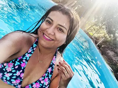 a woman in a swimming pool with a surfboard at Hotel Quilla Wasi in Lunahuaná
