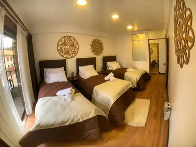 a bedroom with three beds in a room at Apartamento a pasos de la Plaza Cusco Inlove in Cusco