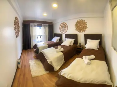 a hotel room with two beds and a room with two beds at Apartamento a pasos de la Plaza Cusco Inlove in Cusco