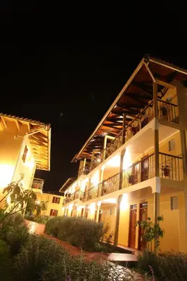 a large white building with a balcony at night at Tunupa Lodge Hotel in Ollantaytambo