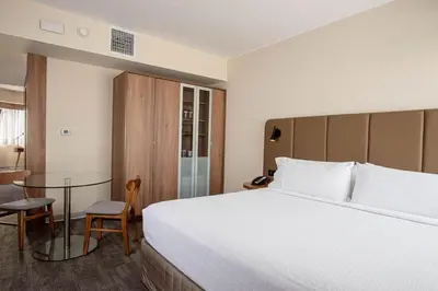 a hotel room with a large bed and a table at Crowne Plaza Lima by IHG in Lima