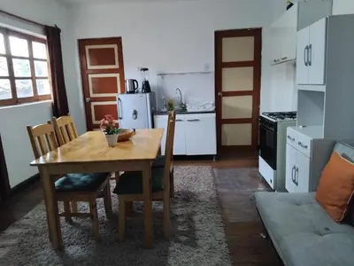 a kitchen with a wooden table and chairs and a kitchen with a couch at Nice studio in historic center with private bathroom and kitchen! in Cusco