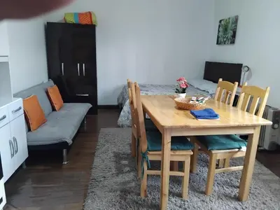 a dining room with a table and chairs and a bed at Nice studio in historic center with private bathroom and kitchen! in Cusco