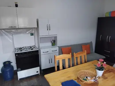 a small kitchen with a couch and a table and a stove at Nice studio in historic center with private bathroom and kitchen! in Cusco