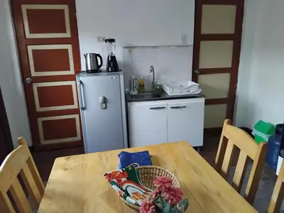 a kitchen with a wooden table and a refrigerator at Nice studio in historic center with private bathroom and kitchen! in Cusco