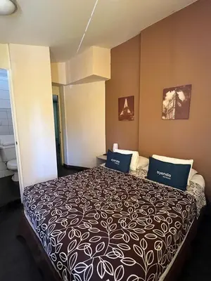 a hotel room with a large bed with blue pillows at B&B Wasi Airport Lima in Lima