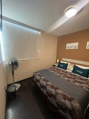 a hotel room with a bed and a fan at B&B Wasi Airport Lima in Lima
