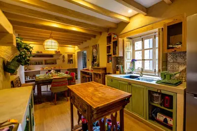 a kitchen with green cabinets and a wooden table at NUNA by DCO in Urubamba