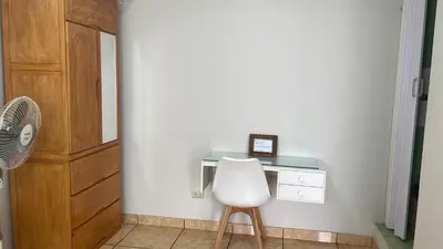 a desk with a white chair in a room at Habitación Alborada 2 con baño privado in Lima