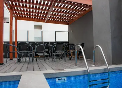 a patio with a table and chairs next to a swimming pool at Departamento 100 m2 con luz natural y Seguridad 24h in Lima