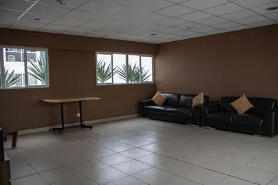a waiting room with couches and a table and windows at Departamento 100 m2 con luz natural y Seguridad 24h in Lima