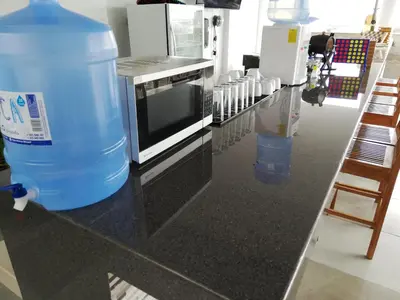a counter with a microwave and a water tank on it at ica wasi hostel in Ica