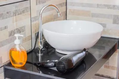 a bathroom counter with a sink and a bowl at ica wasi hostel in Ica