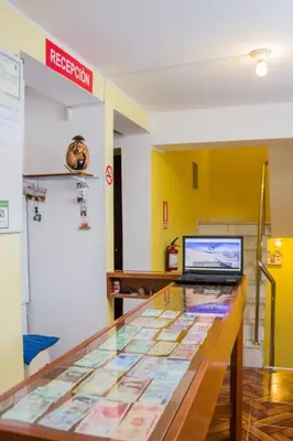 a glass counter with a laptop on top of it at ica wasi hostel in Ica