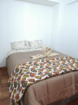 a bed with a comforter with faces on it at Casa ValPer in Cusco