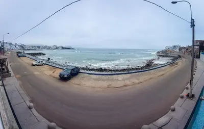 a road next to the ocean with cars parked on it at Departamento de playa - Condominio OCEAN REEF - SAN BARTOLO in San Bartolo