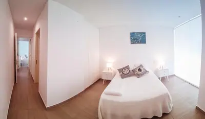 a white bedroom with a white bed with pillows on it at Departamento de playa - Condominio OCEAN REEF - SAN BARTOLO in San Bartolo