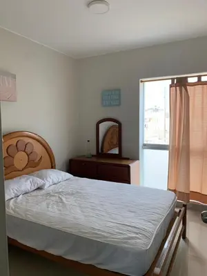 a bedroom with a bed and a dresser and a mirror at DEPARTAMENTO SAN BARTOLO-2dormitorios in Lima