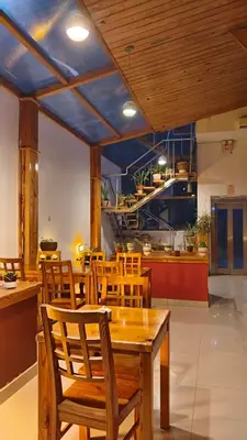 a dining room with a table and chairs and a kitchen at Fenix Hotel Machupicchu in Machu Picchu