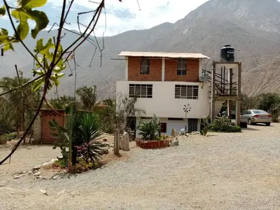 a house in the desert with mountains in the background at Cabañas o habitación en Fundo Huabayor in Lima
