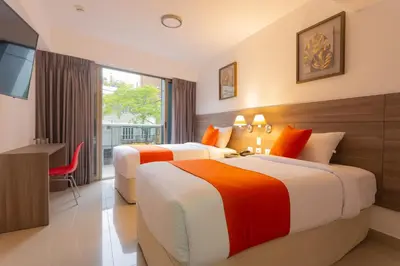 two beds in a hotel room with a television at Howard Johnson by Wyndham Lima Miraflores Art House in Lima
