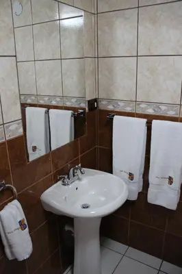 a bathroom with a sink and a mirror and towels at Hotel Marqueses in Cusco