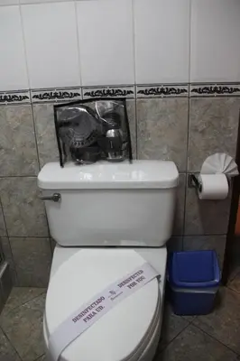a toilet with a sign on the top of it at Hotel Marqueses in Cusco