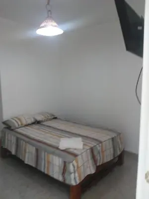 a small bed in a room with a lamp at Olas inn in Asia
