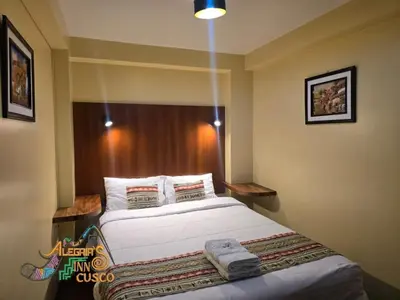 a bedroom with a large bed with white sheets at Marvelous Plaza in Cusco