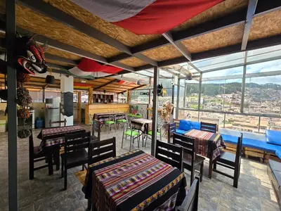 a dining room with tables and chairs and windows at Marvelous Plaza in Cusco