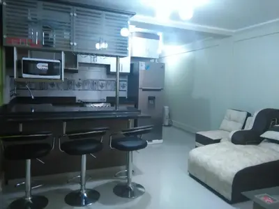 a kitchen with a bar and a couch in a room at PYMABET in Huancavelica