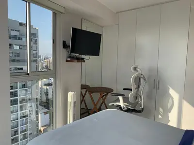 a bedroom with a bed and a tv and a chair at Connect in Lima