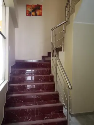 a set of stairs in a building with a painting on the wall at Hotel ARKONA in Huancayo