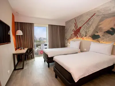 a hotel room with two beds and a desk at ibis Styles Lima Benavides Miraflores in Lima