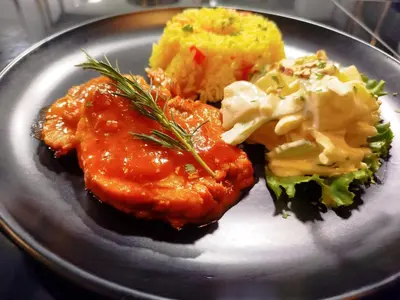 a plate of food with meat and broccoli and sauce at Hotel Konford Cañete in Imperial