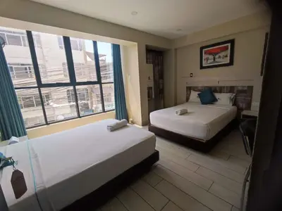 a hotel room with two beds and a large window at Hotel Konford Cañete in Imperial