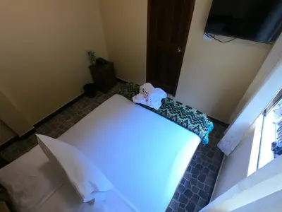 a room with a white bed in a room at Don Feli House in Machu Picchu