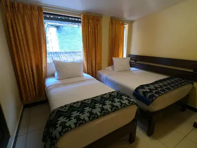 two beds in a room with a window at Don Feli House in Machu Picchu