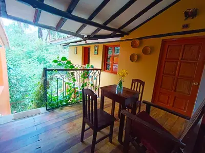 a dining room with a table and chairs and a door at Wayras Hostal in Ollantaytambo