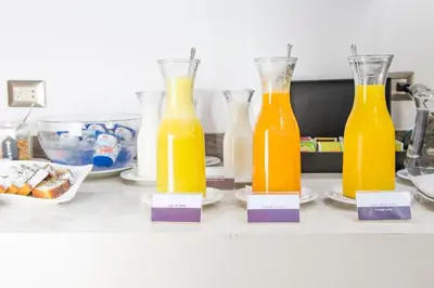 three bottles of orange juice sitting on a counter at Aku Hotels in Lima