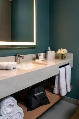 a bathroom with a sink and a mirror and towels at Fairfield by Marriott Lima Miraflores in Lima