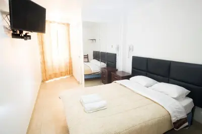 a bedroom with a large bed with a black headboard at Hostal Sueños Breña in Lima
