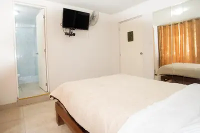 a bedroom with a bed and a tv on the wall at Hostal Sueños Breña in Lima