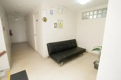 a black leather couch in a waiting room at Hostal Sueños Breña in Lima