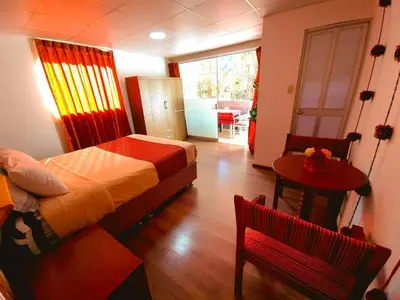 a bedroom with a bed and a table and a chair at Valle verde, Hostel & camping in Urubamba