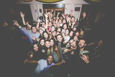 a group of people posing for a picture with their hands in the air at Loki Cusco in Cusco