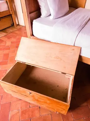 a wooden bed frame with a drawer next to a bed at Loki Cusco in Cusco